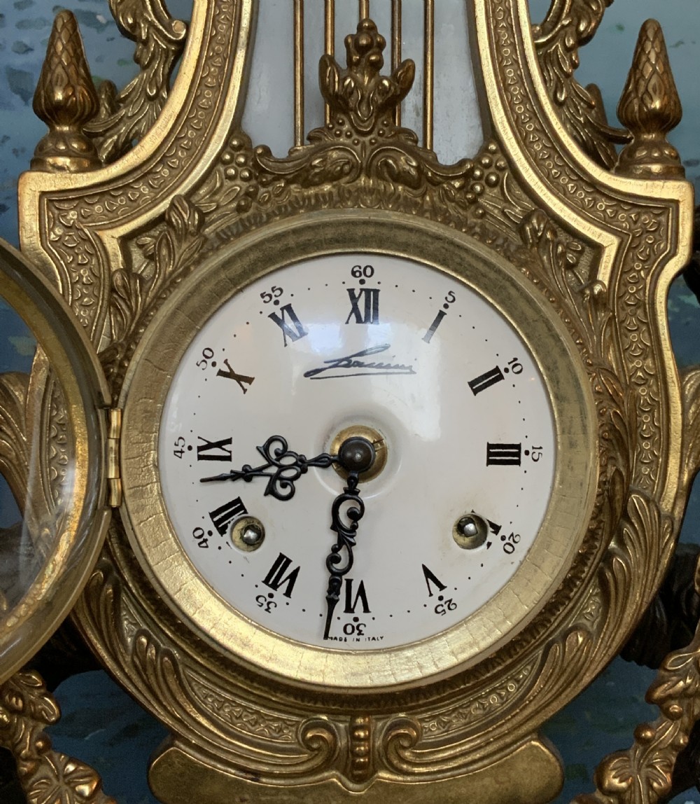 A three-piece antique clock garniture set featuring a central gilt bronze and white marble clock flanked by two matching multi-arm candelabra. View VIII