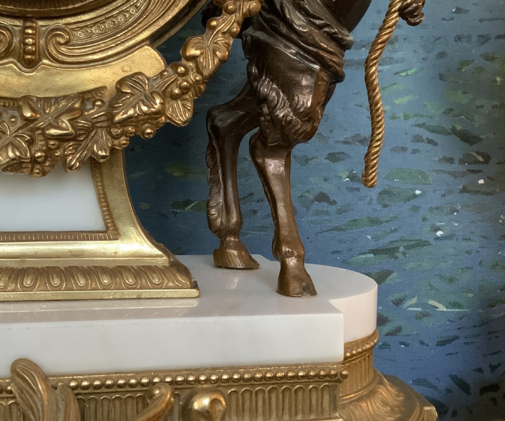 A three-piece antique clock garniture set featuring a central gilt bronze and white marble clock flanked by two matching multi-arm candelabra. View X