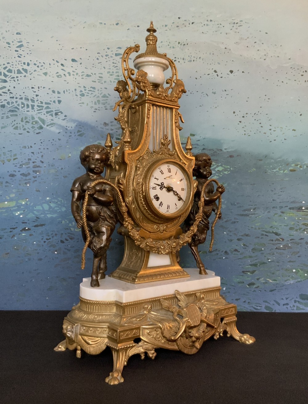 A three-piece antique clock garniture set featuring a central gilt bronze and white marble clock flanked by two matching multi-arm candelabra. View XVII