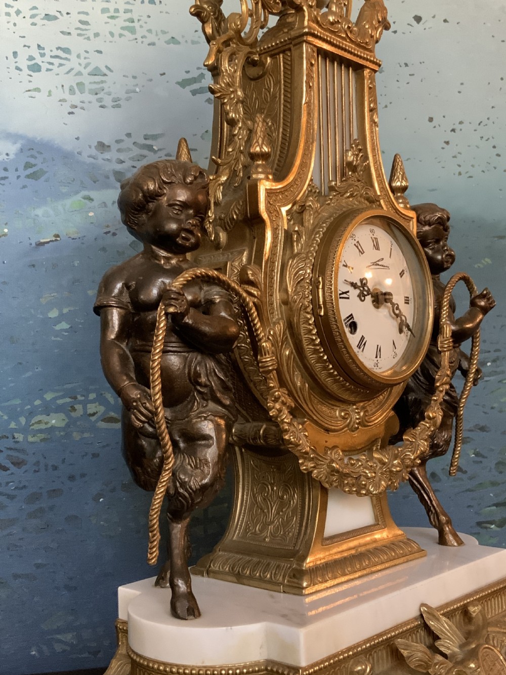 A three-piece antique clock garniture set featuring a central gilt bronze and white marble clock flanked by two matching multi-arm candelabra. View XVIII