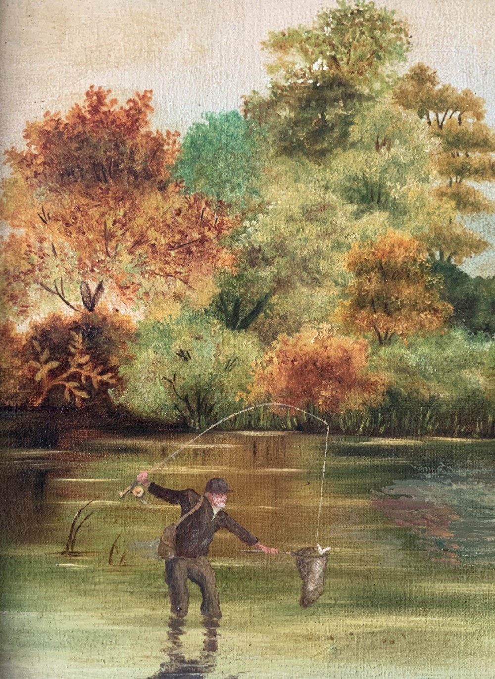 An Edwardian oil painting depicting an angler fly fishing in a river surrounded by trees, enclosed in a moulded gold gilt frame. View VII