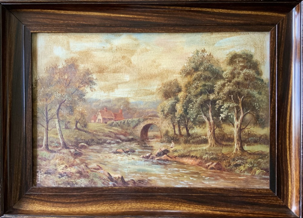 An antique oil painting depicting a tranquil river flowing through a wooded landscape with a stone bridge and cottage in the background, framed in polished dark wood.
