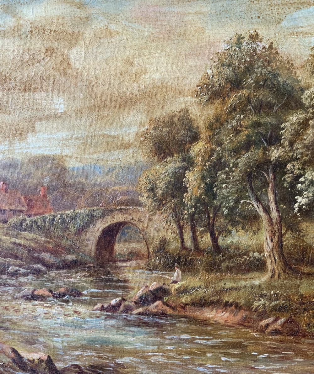 An antique oil painting depicting a tranquil river flowing through a wooded landscape with a stone bridge and cottage in the background, framed in polished dark wood. View VI