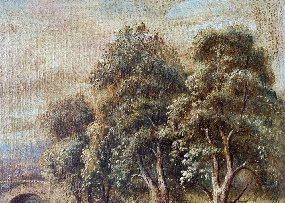 An antique oil painting depicting a tranquil river flowing through a wooded landscape with a stone bridge and cottage in the background, framed in polished dark wood. View X