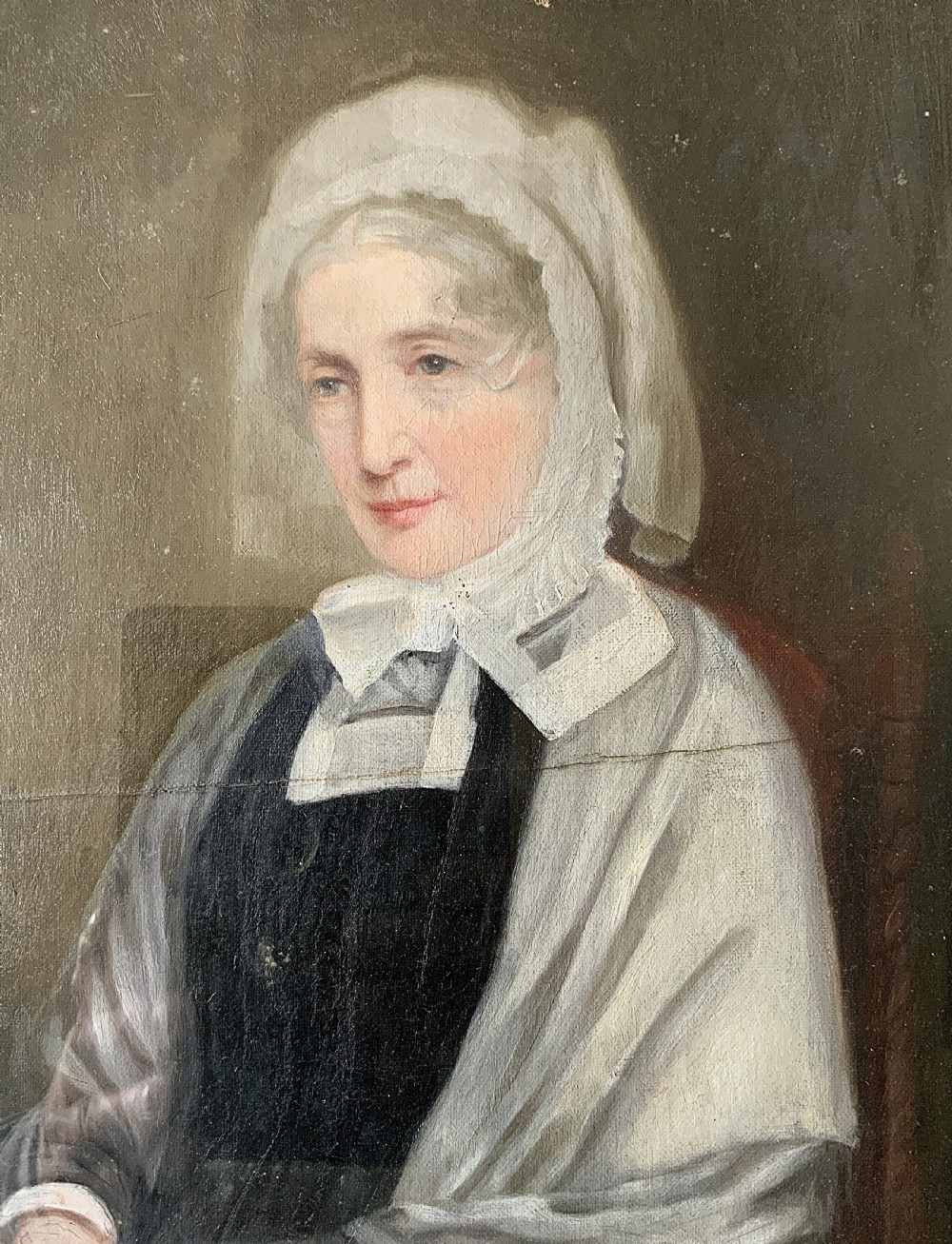 A nineteenth-century oil portrait painting depicting a seated lady wearing a white lace bonnet and grey shawl, housed in a black ebonised frame with a pale inner slip. View VI
