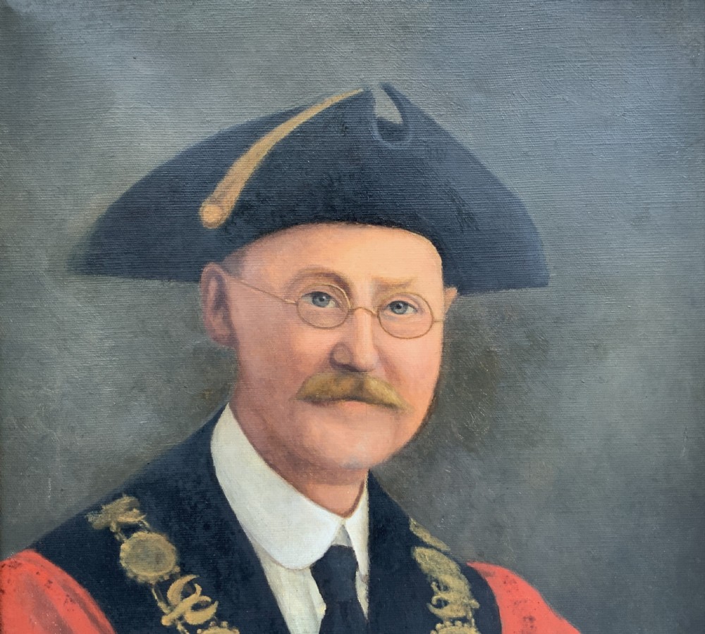 An oil portrait of a bespectacled man with a moustache wearing a tricorne hat, dark tie, red ceremonial robes, and a gold mayors chain of office, presented in a gilded wood frame. View IV