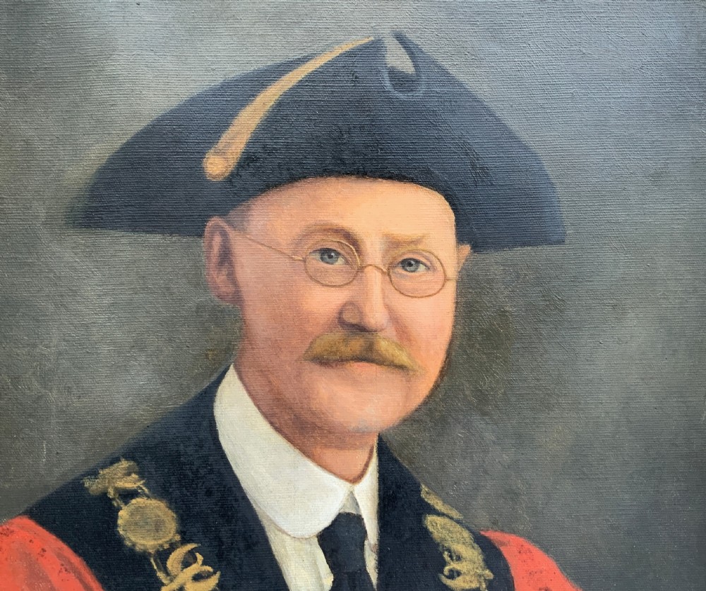 An oil portrait of a bespectacled man with a moustache wearing a tricorne hat, dark tie, red ceremonial robes, and a gold mayors chain of office, presented in a gilded wood frame. View V