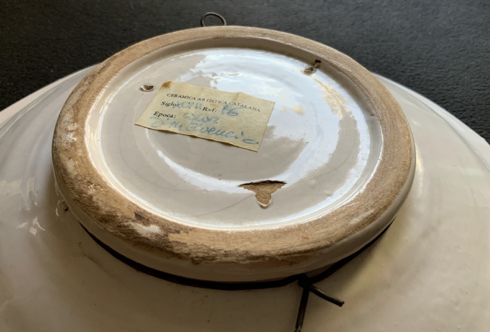 An 18th-century circular Spanish faience charger plate featuring a hand-painted equestrian figure framed by a blue patterned border and a yellow rim. View X
