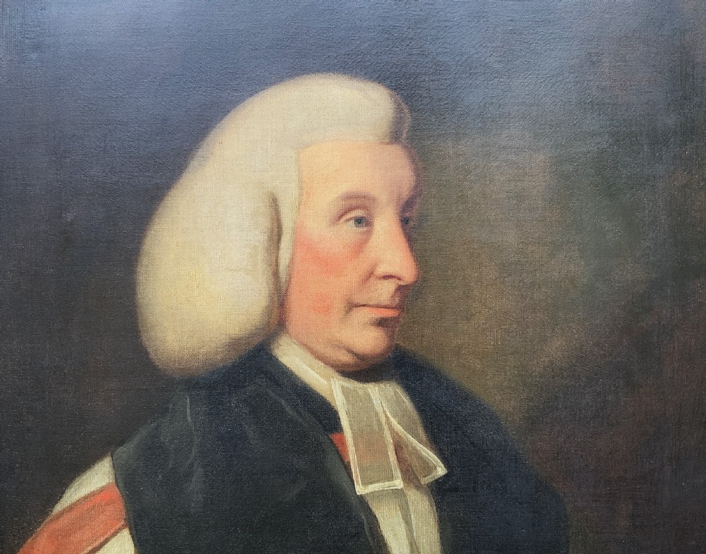 An 18th-century oil portrait of a clergyman in a powdered wig and clerical bands, framed in a carved giltwood frame. View V