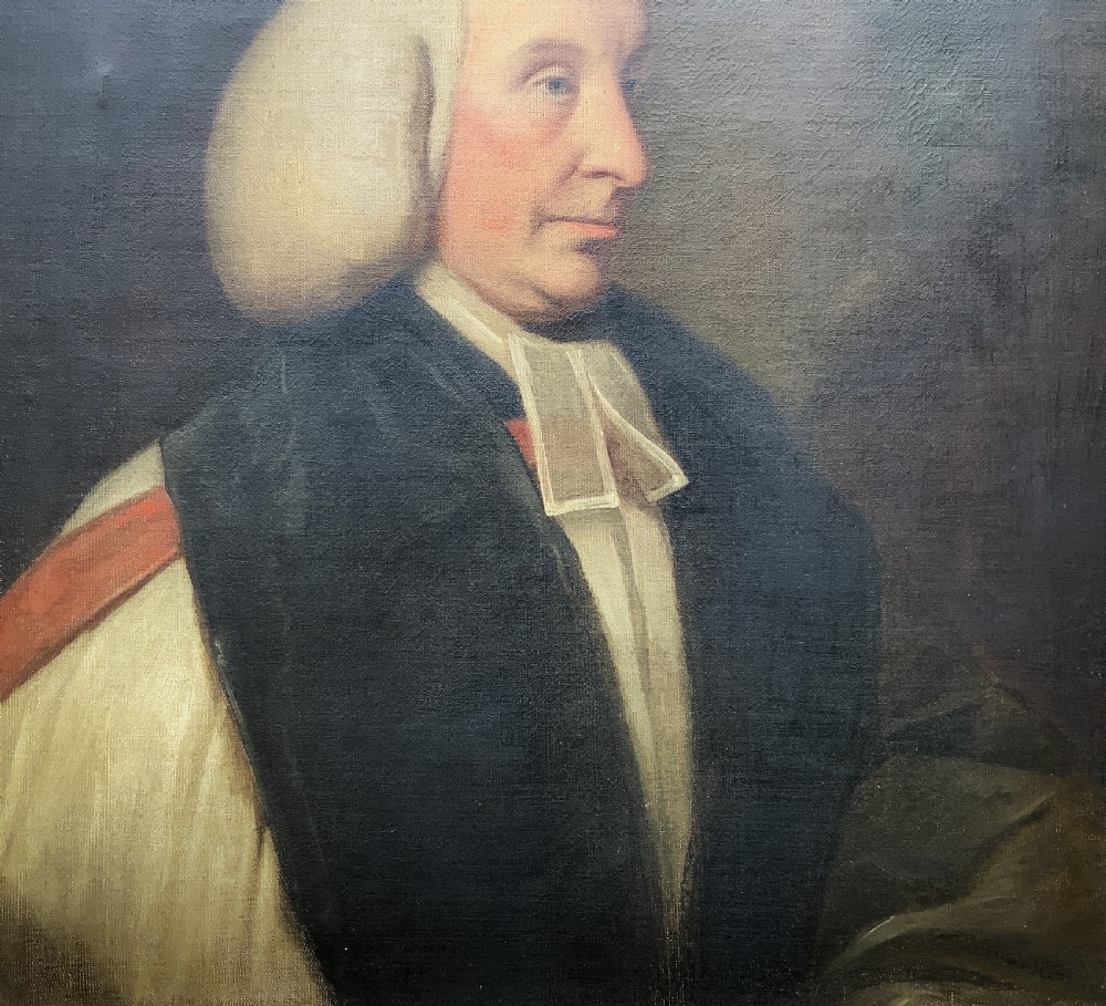 An 18th-century oil portrait of a clergyman in a powdered wig and clerical bands, framed in a carved giltwood frame. View VI