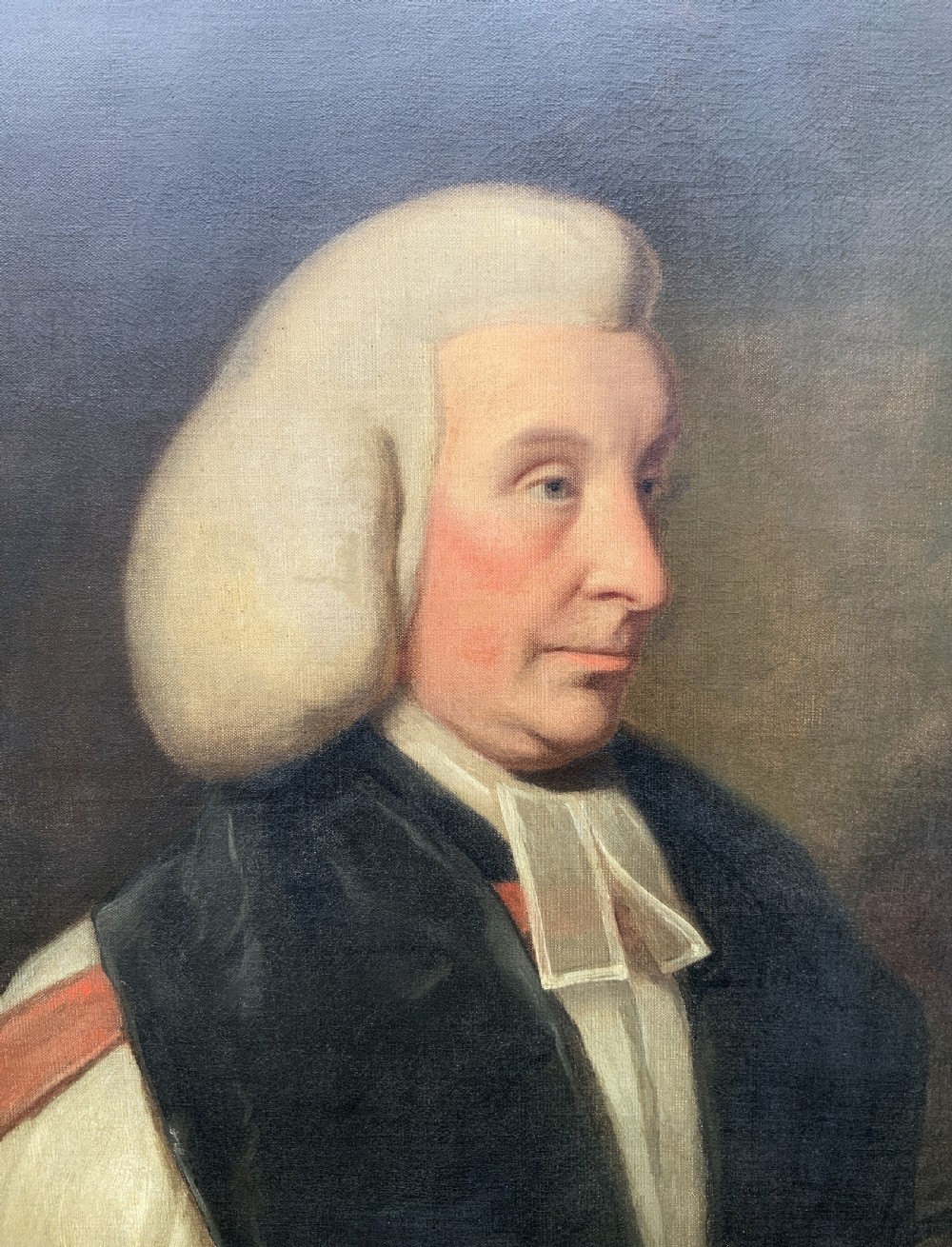 An 18th-century oil portrait of a clergyman in a powdered wig and clerical bands, framed in a carved giltwood frame. View VIII