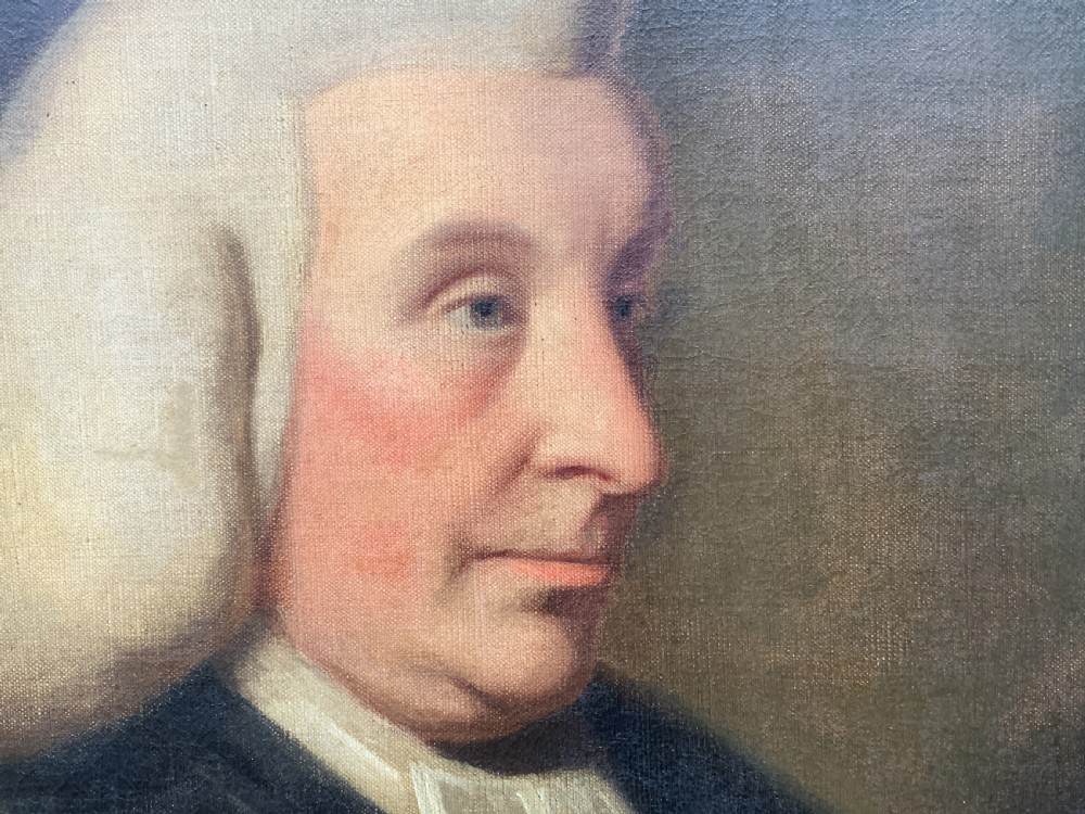 An 18th-century oil portrait of a clergyman in a powdered wig and clerical bands, framed in a carved giltwood frame. View X