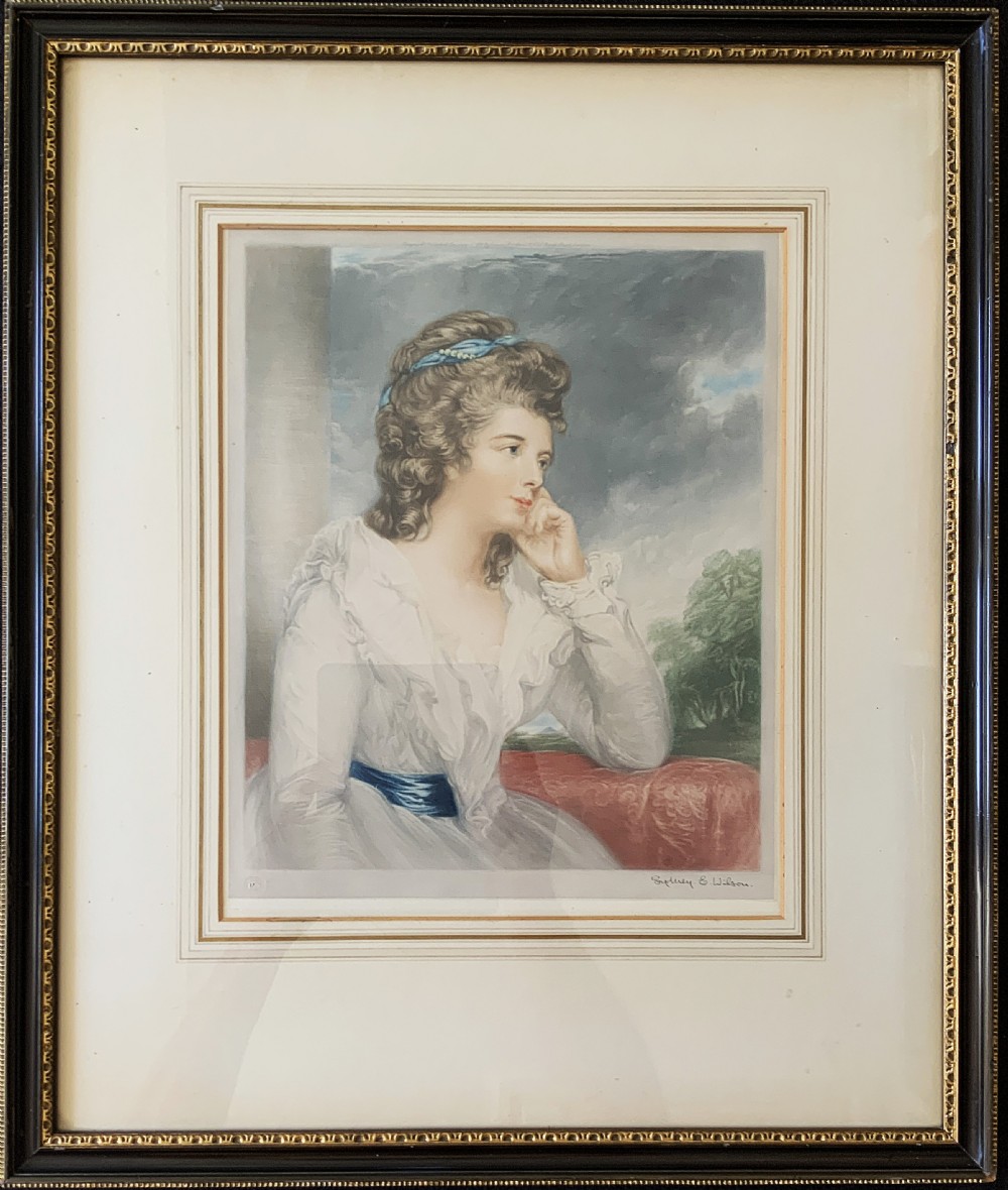 Framed early 20th-century coloured mezzotint print depicting a profile portrait of a lady in a white dress with a blue sash, signed in pencil by Sydney Wilson. View XII