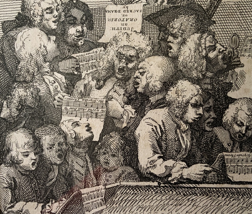 A framed monochrome etching depicting a group of 18th-century choir singers holding music scores, set within a cream mount and a black and gold moulding frame. View IV