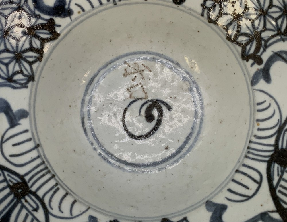 A 17th-century Chinese Swatow porcelain bowl featuring hand-painted underglaze blue geometric and floral motifs on an off-white glazed surface. View VII