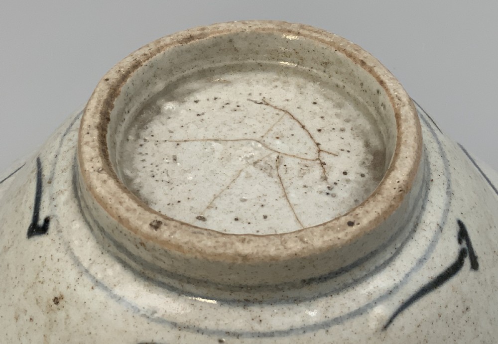 A 17th-century Chinese Swatow porcelain bowl featuring hand-painted underglaze blue geometric and floral motifs on an off-white glazed surface. View XI