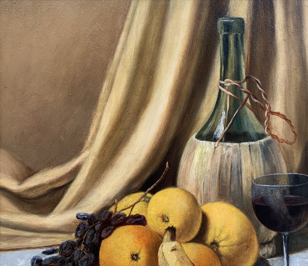 An Edwardian still life oil painting depicting citrus fruit, bananas, grapes, and a glass of wine on a tablecloth, set inside a heavy gold gilded frame. View IV