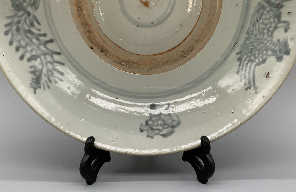 A large circular Ming Dynasty Swatow porcelain charger displaying hand-painted grey-blue phoenix motifs around an unglazed central ring. View VI