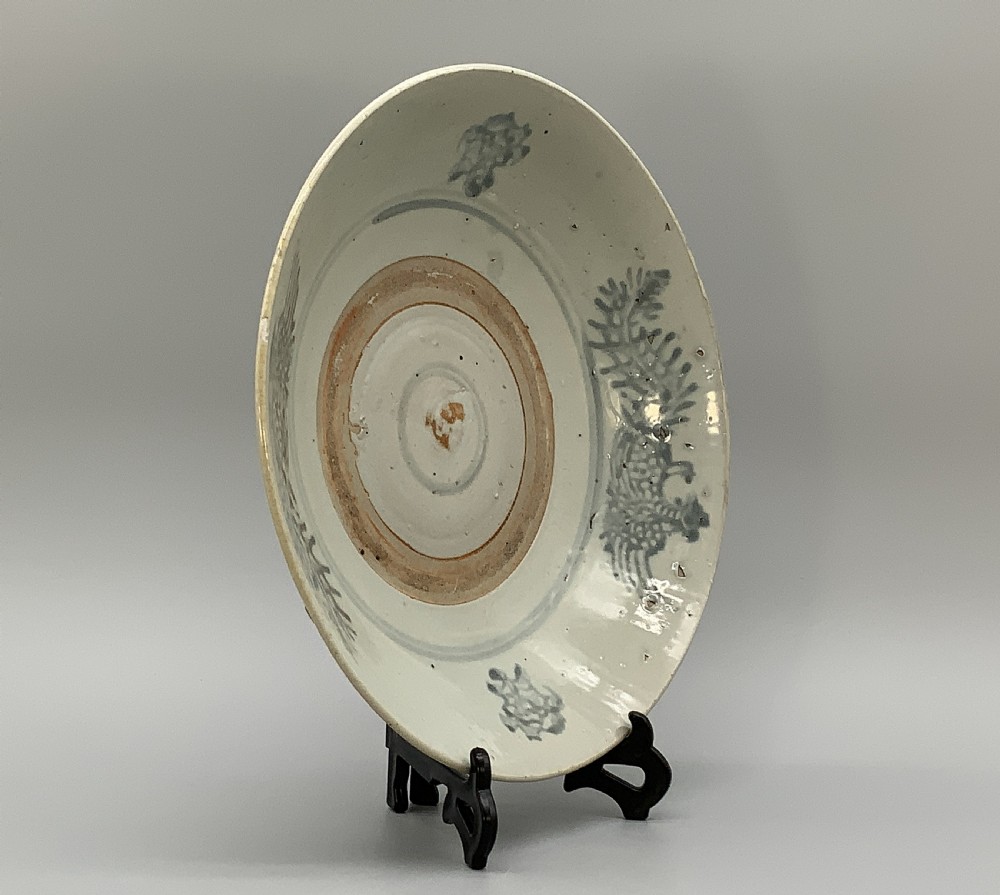 A large circular Ming Dynasty Swatow porcelain charger displaying hand-painted grey-blue phoenix motifs around an unglazed central ring. View VII