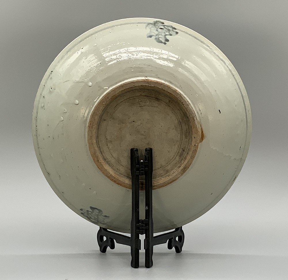 A large circular Ming Dynasty Swatow porcelain charger displaying hand-painted grey-blue phoenix motifs around an unglazed central ring. View IX