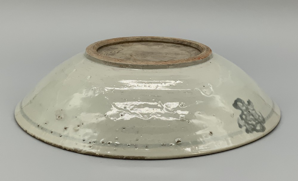 A large circular Ming Dynasty Swatow porcelain charger displaying hand-painted grey-blue phoenix motifs around an unglazed central ring. View XII