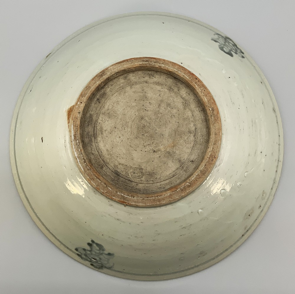 A large circular Ming Dynasty Swatow porcelain charger displaying hand-painted grey-blue phoenix motifs around an unglazed central ring. View XV
