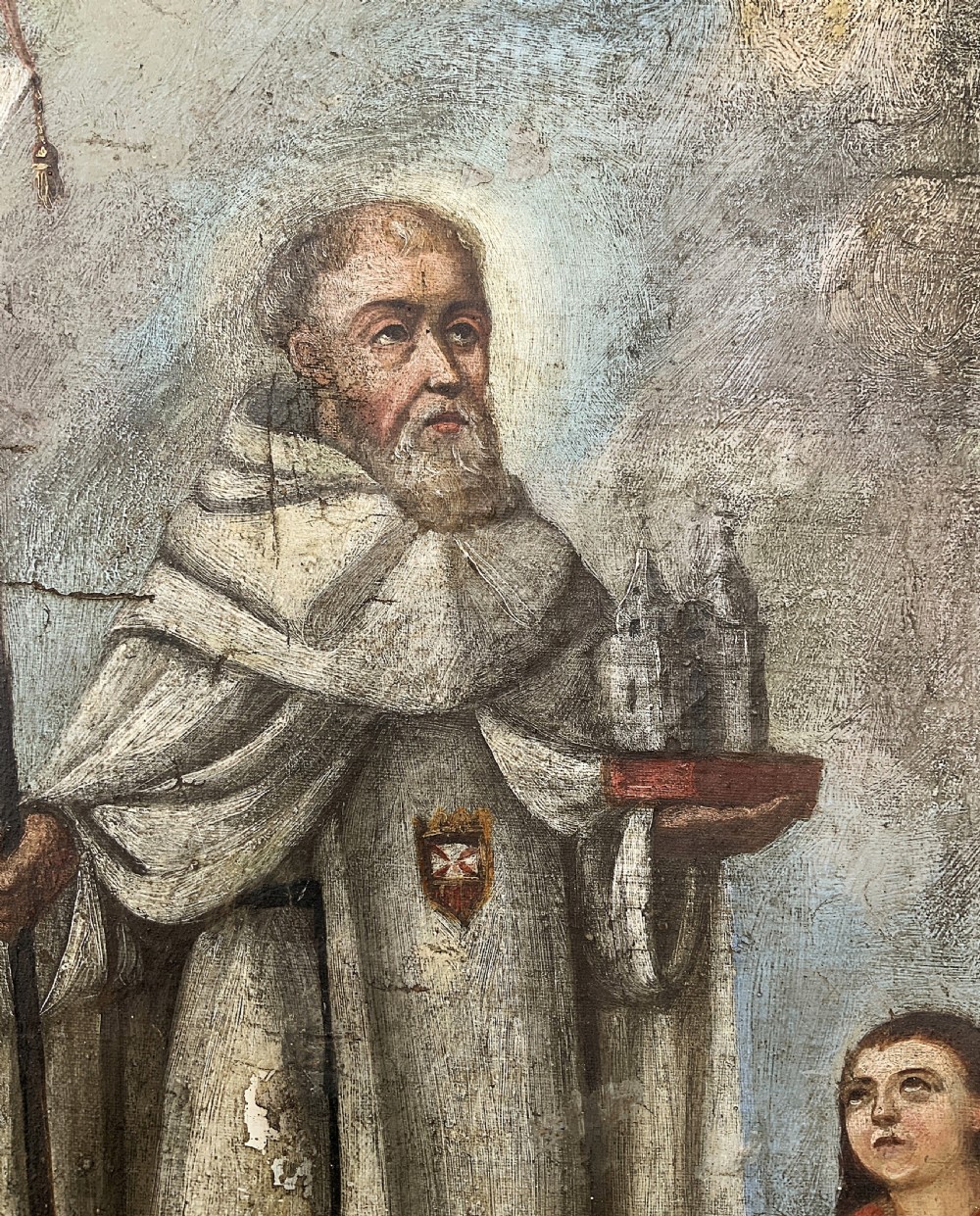A 17th-century Spanish Baroque oil painting depicting a saint in a habit holding a banner alongside a kneeling figure, housed within an ornate carved giltwood lattice frame with mirrored glass inserts. View VI