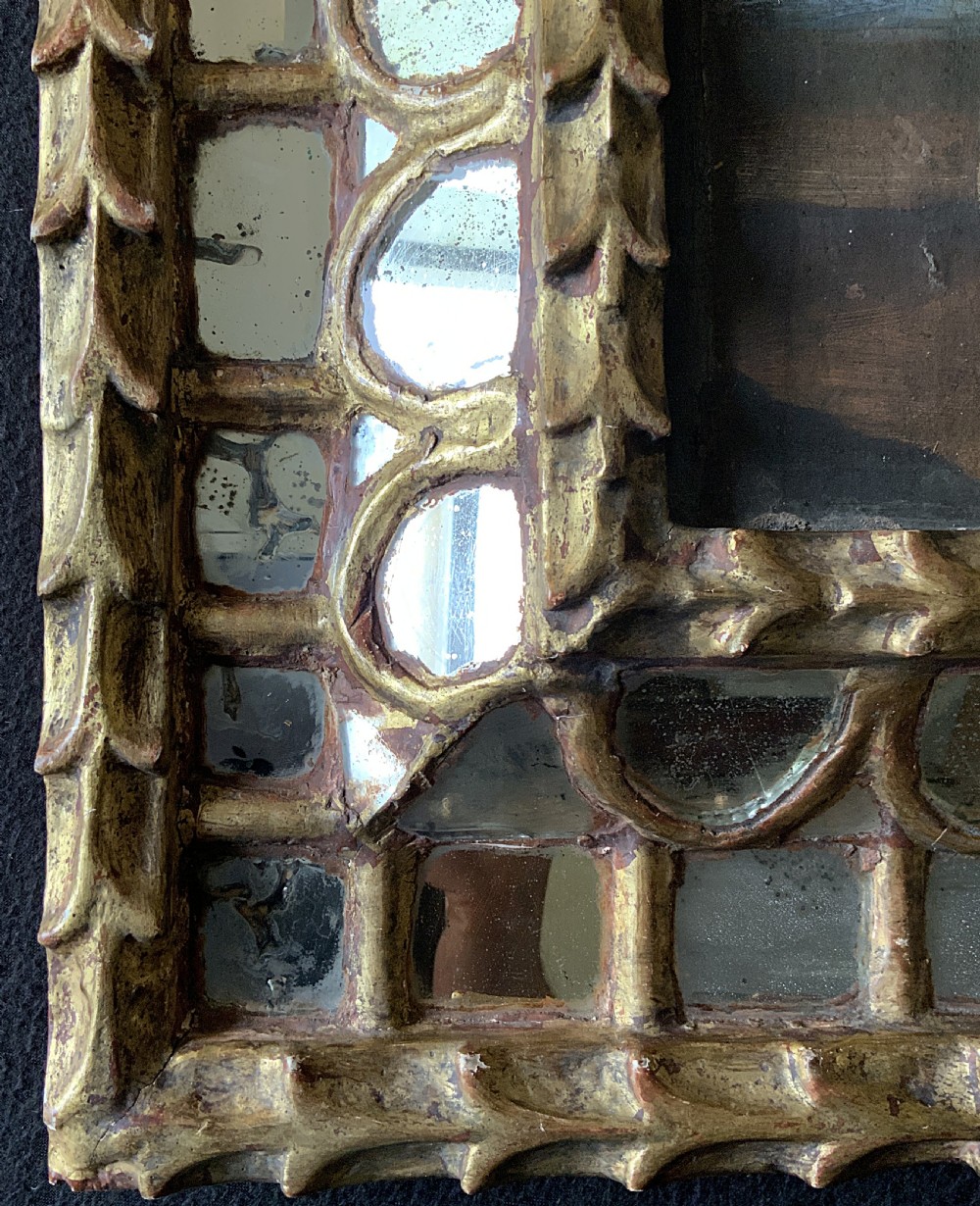 A 17th-century Spanish Baroque oil painting depicting a saint in a habit holding a banner alongside a kneeling figure, housed within an ornate carved giltwood lattice frame with mirrored glass inserts. View XIV