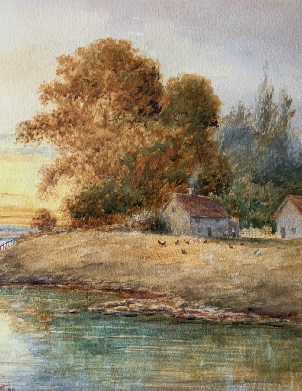 Framed antique watercolour painting depicting a figure fishing along a riverbank at sunset beside trees and cottages. View III