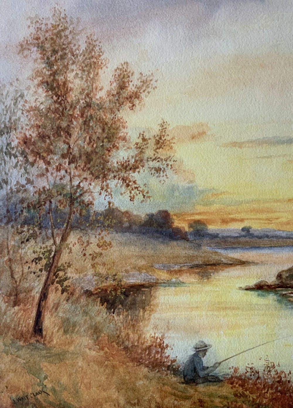 Framed antique watercolour painting depicting a figure fishing along a riverbank at sunset beside trees and cottages. View IX
