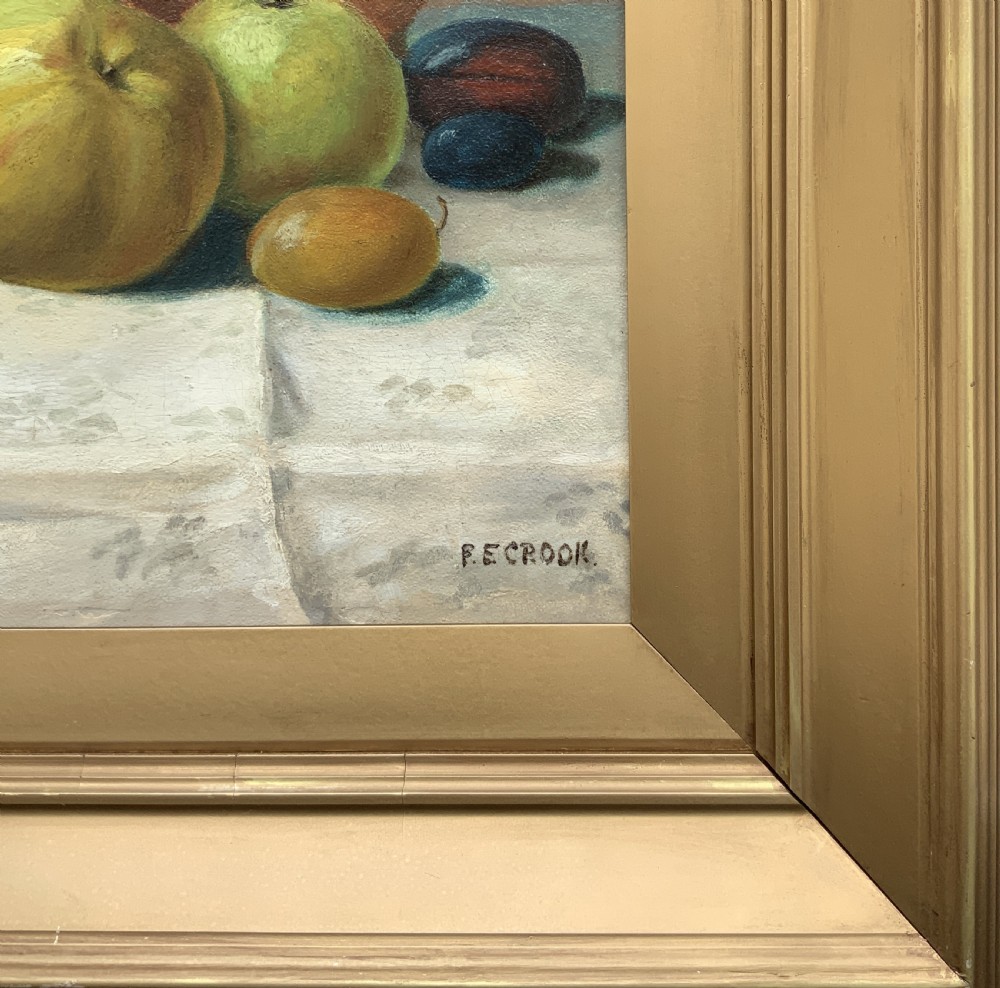 An Edwardian oil painting depicting a tabletop arrangement of apples, plums, and a green vase inside a broad gilt frame. View IX