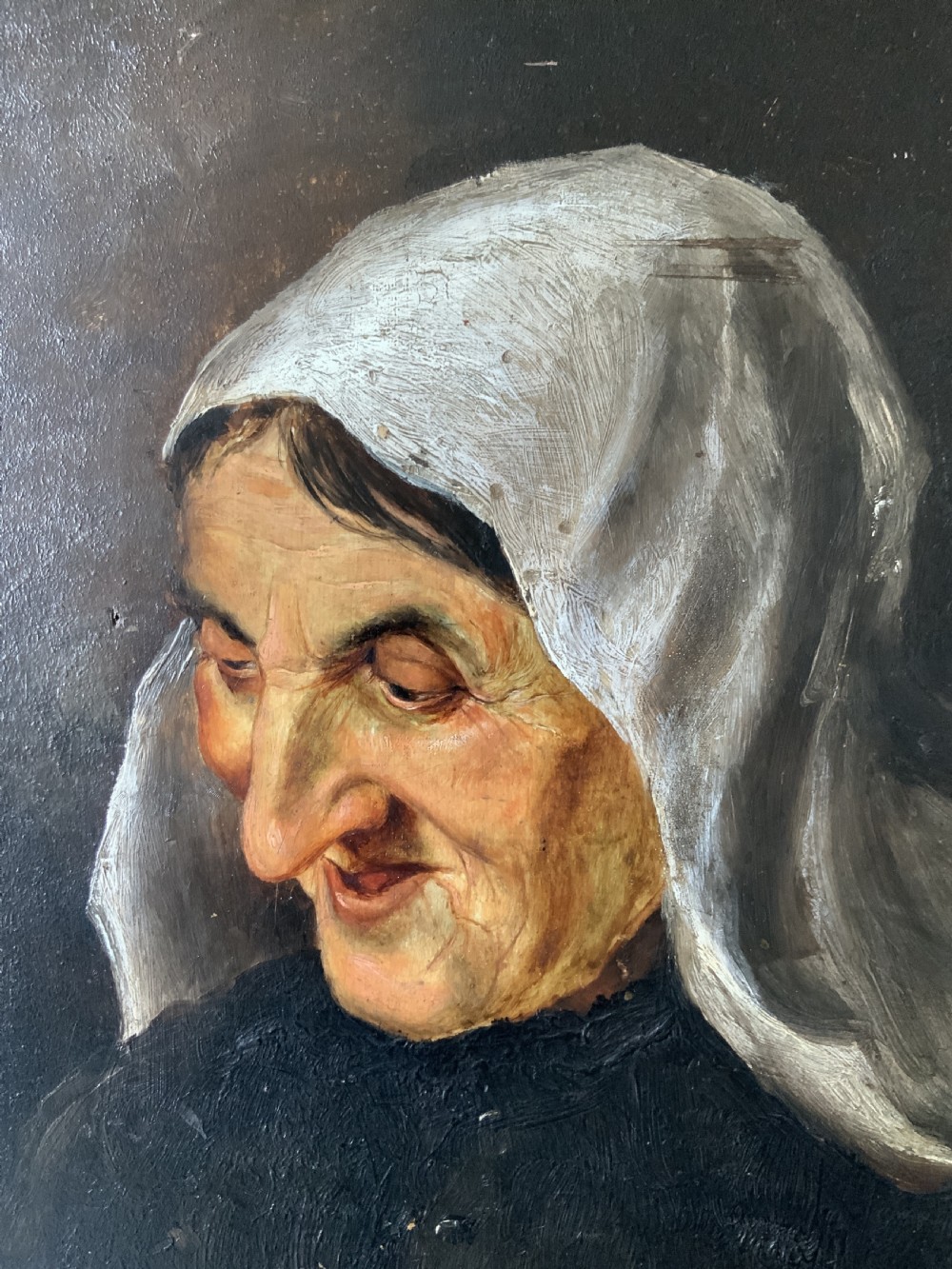 A 19th-century oil portrait painting depicting an elderly woman in a white headscarf looking downwards, set inside a silver-toned moulded frame. View IV