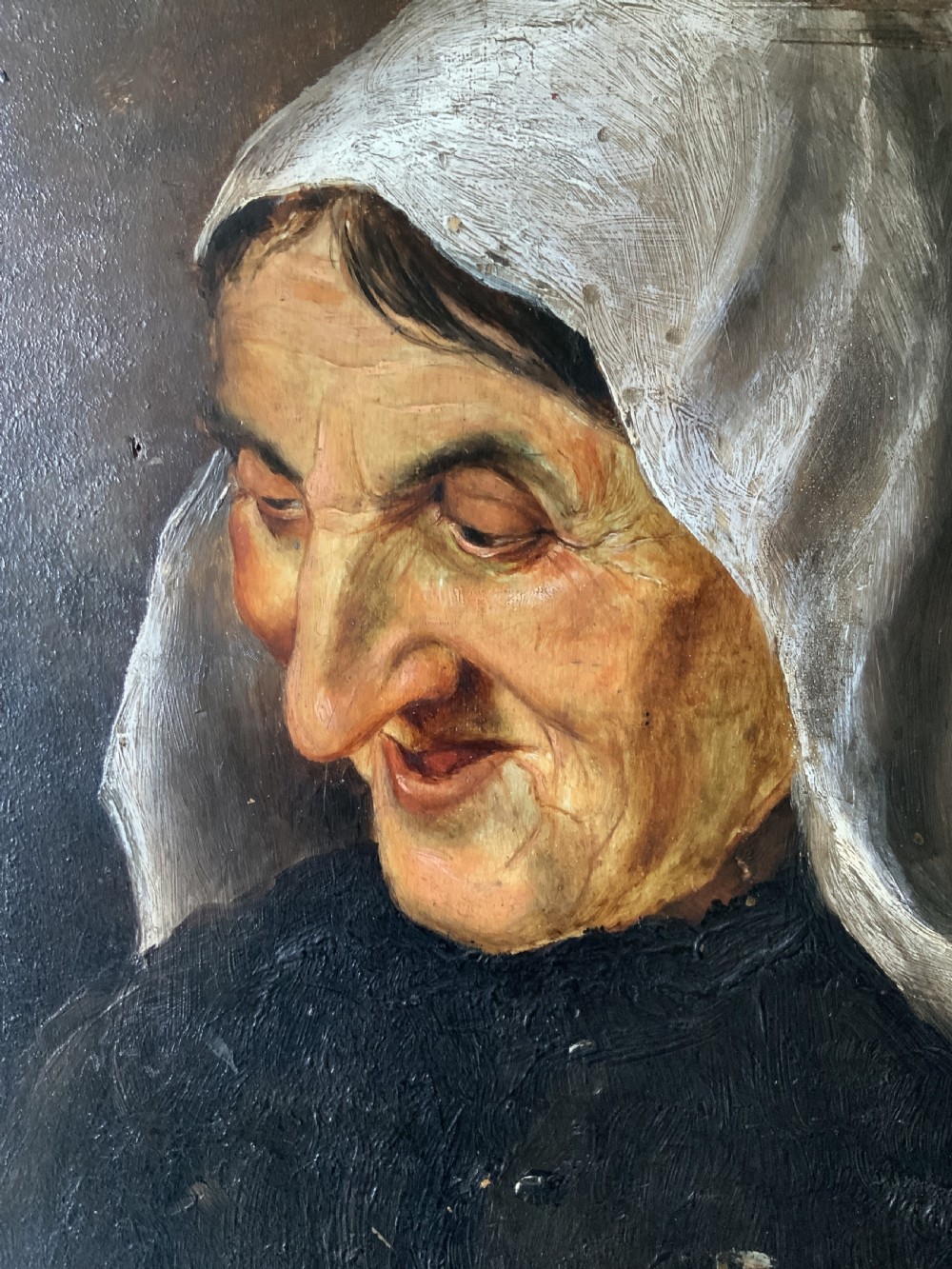 A 19th-century oil portrait painting depicting an elderly woman in a white headscarf looking downwards, set inside a silver-toned moulded frame. View V