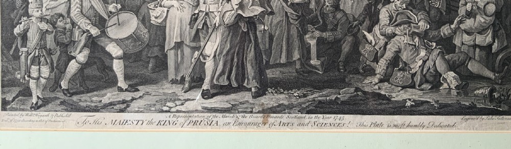 An 18th-century black and white satirical engraving depicting a crowded street scene with soldiers, housed in a black and gold frame with a cream mount. View VI