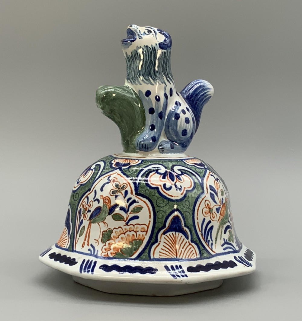 An octagonal tin-glazed ceramic baluster vase with a matching cover topped by a sculpted lion finial and decorated with multi-coloured floral panels. View XIII