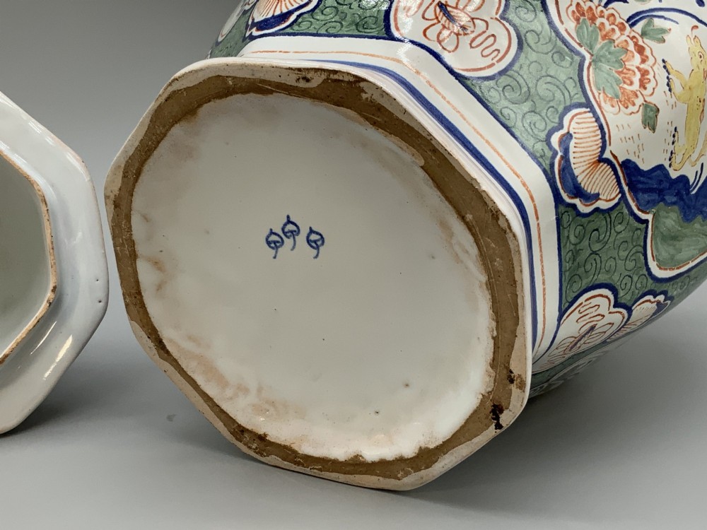 An octagonal tin-glazed ceramic baluster vase with a matching cover topped by a sculpted lion finial and decorated with multi-coloured floral panels. View XIV