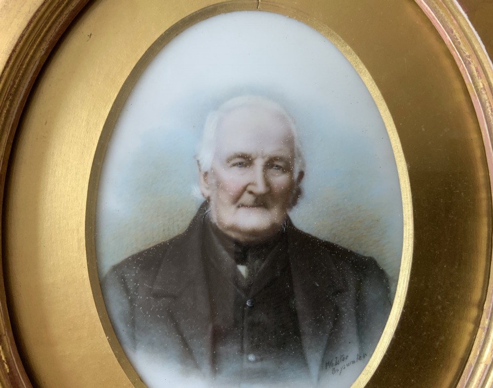 An oval Victorian miniature watercolour portrait of an elderly gentleman in a dark suit, set within a gilded frame. View IV