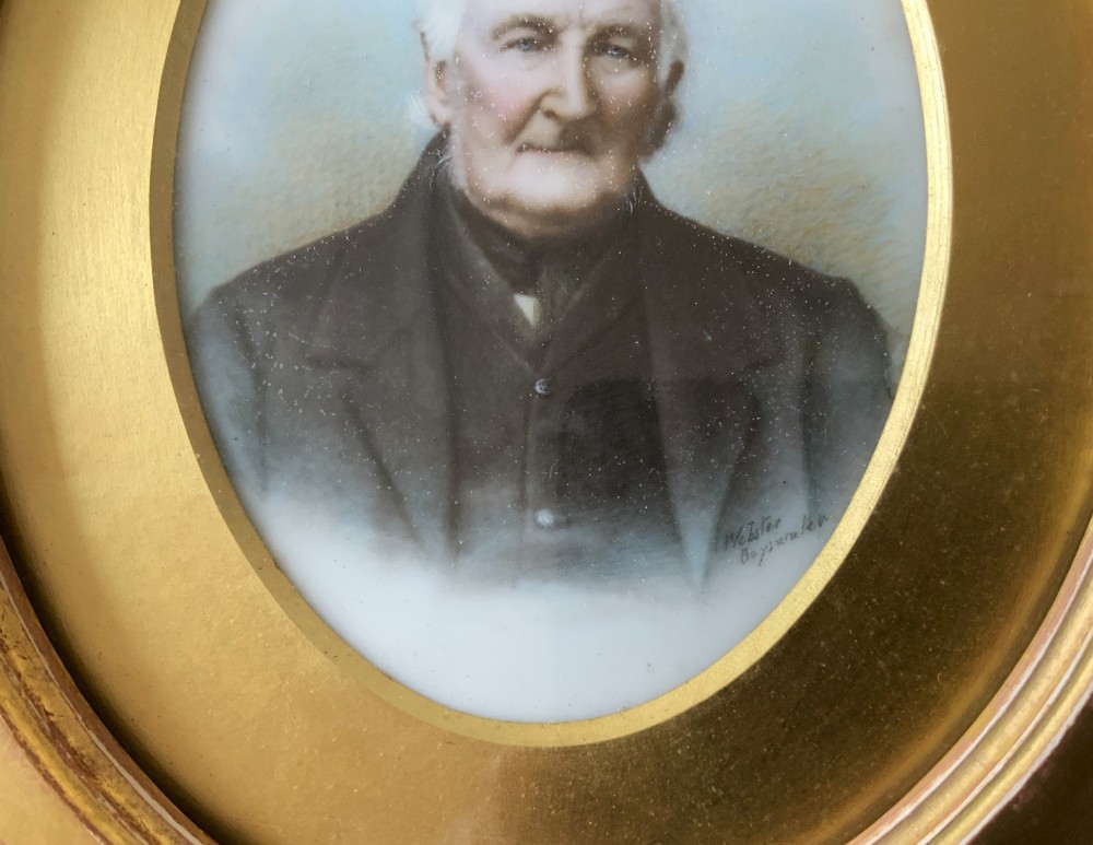 An oval Victorian miniature watercolour portrait of an elderly gentleman in a dark suit, set within a gilded frame. View V