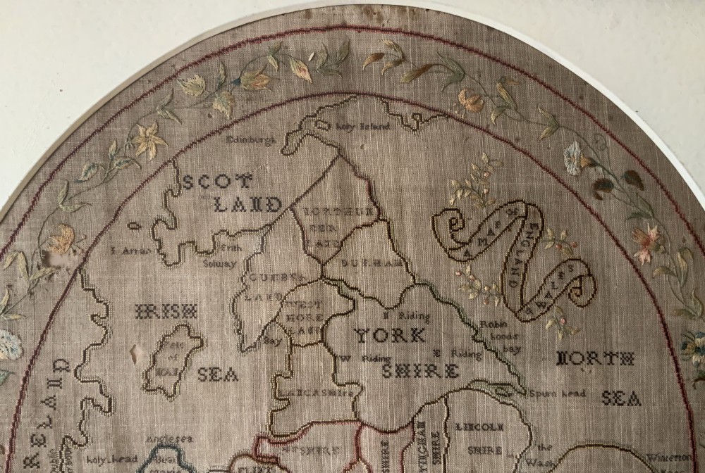 An oval Georgian embroidered needlepoint map of England and Wales with floral borders inside a gilt wooden frame. View V