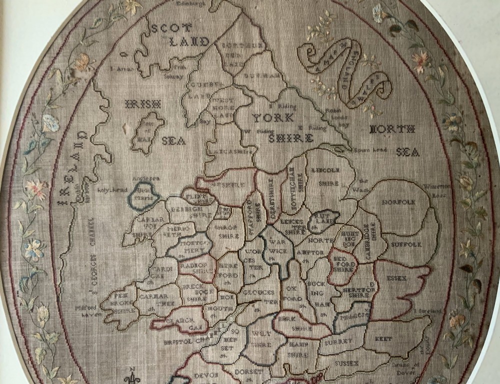 An oval Georgian embroidered needlepoint map of England and Wales with floral borders inside a gilt wooden frame. View VI