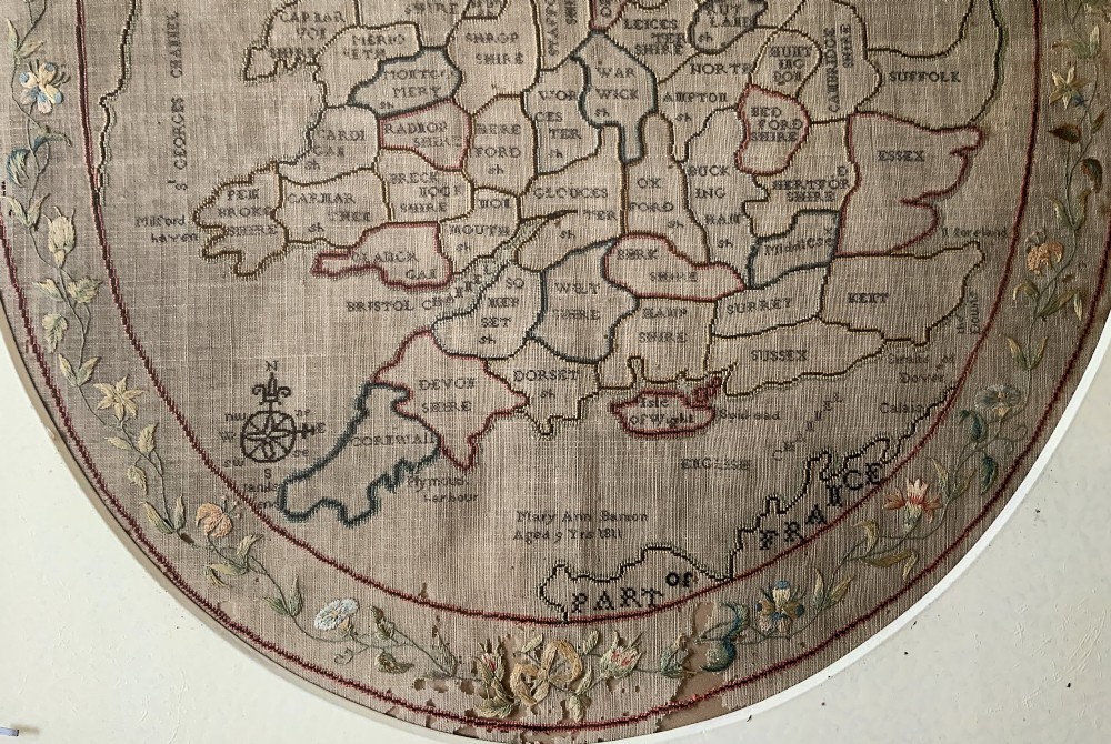An oval Georgian embroidered needlepoint map of England and Wales with floral borders inside a gilt wooden frame. View VII