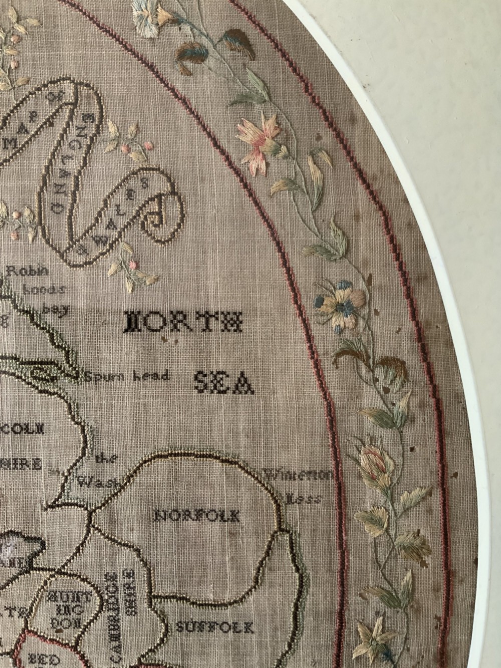 An oval Georgian embroidered needlepoint map of England and Wales with floral borders inside a gilt wooden frame. View X