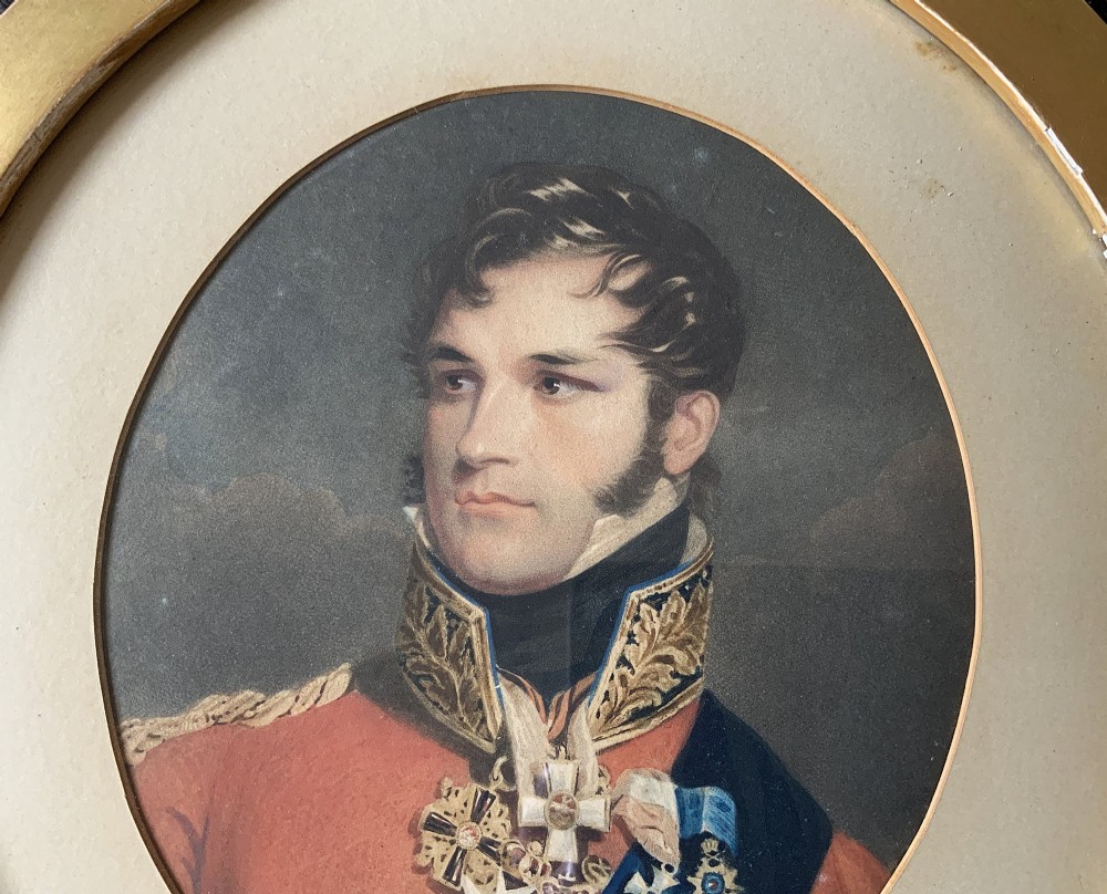 A circular gilt-framed miniature portrait print depicting a man in a red military uniform with medals and a blue sash. View IV
