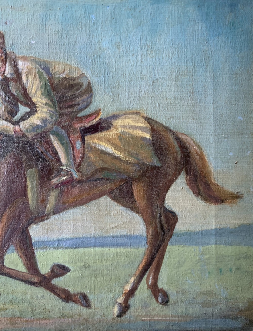 An antique oil painting depicting a jockey riding a brown racehorse across a green landscape against a blue sky, set within a gilded frame. View VI