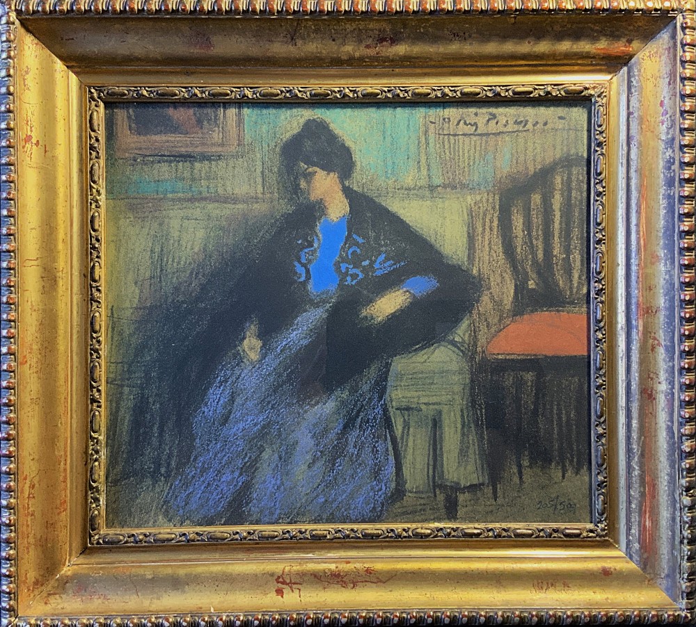 A framed limited-edition portrait print depicting a seated woman in a blue top and dark shawl, housed within a wide gilt decorative frame.