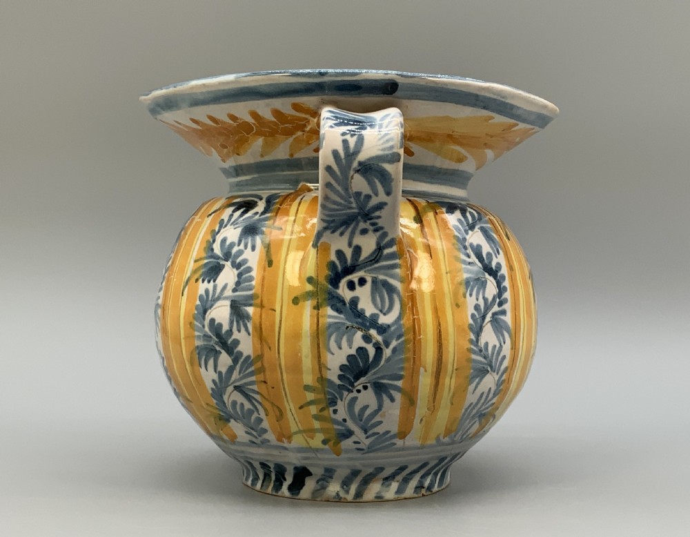 An antique Italian majolica earthenware pharmacy jug with hand-painted yellow, blue, and manganese script reading CARA BEVI IN PACE. View VI