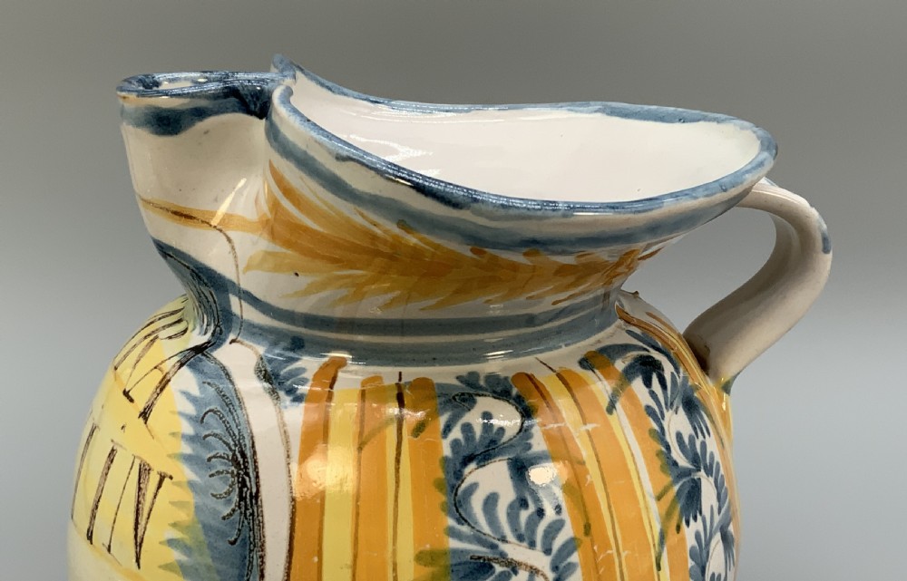 An antique Italian majolica earthenware pharmacy jug with hand-painted yellow, blue, and manganese script reading CARA BEVI IN PACE. View XII