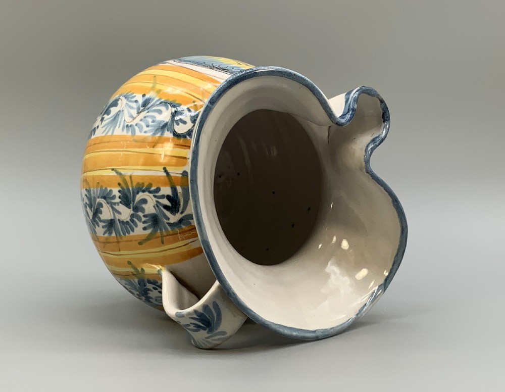 An antique Italian majolica earthenware pharmacy jug with hand-painted yellow, blue, and manganese script reading CARA BEVI IN PACE. View XV