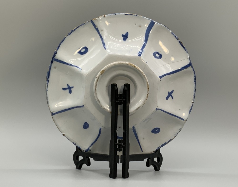 A blue and white tin-glazed earthenware lobed dish featuring panelled borders and a central Chinoiserie landscape scene. View XII