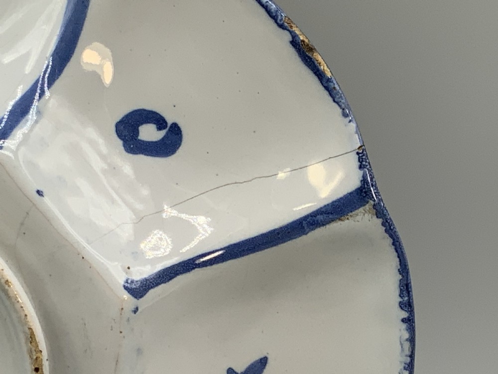 A blue and white tin-glazed earthenware lobed dish featuring panelled borders and a central Chinoiserie landscape scene. View XIV